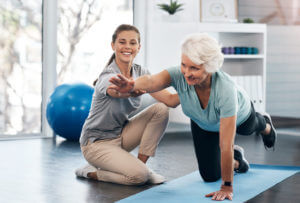 Physical therapist assisting senior woman