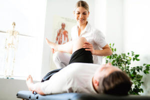 Physical therapist assisting man in physical therapy