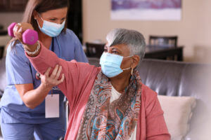 Woman help in old woman in physical therapy