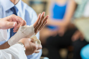 Doctor doing bandage on man hand