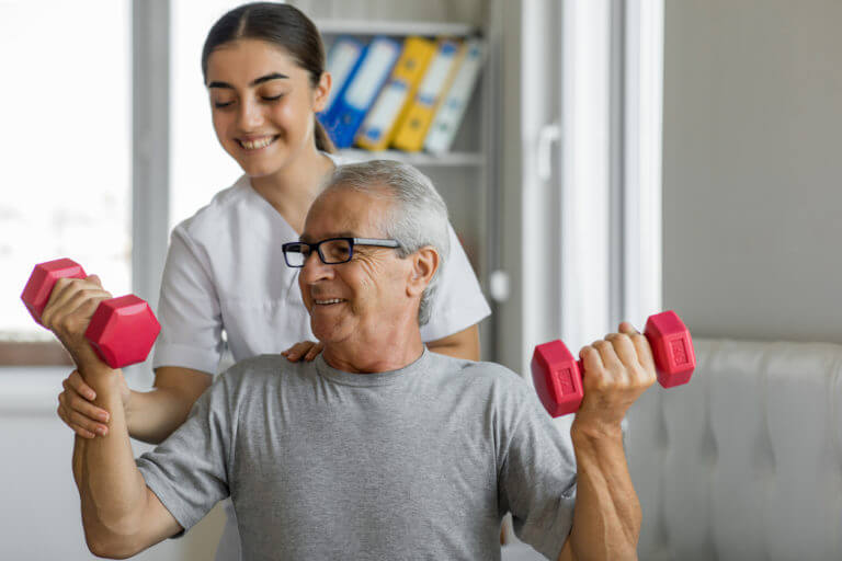 An elderly man undergoing physical therapy with a female physical therapist.