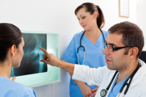 medical team examining X-ray image of hip fracture