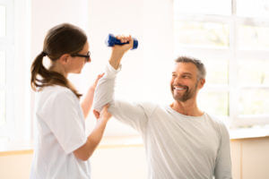 Physical Rehabilitation Therapist Helping Man