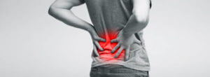 Millennial man touching his sore loin, suffering from kidney inflammation, back view, panorama
