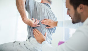 Doctor examining patient's back problem at orthopedic clinic
