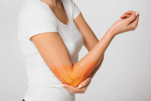 woman suffering pain in the elbow. Composite of image arm bones and elbow