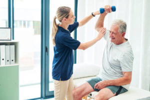 Physiotherapy, fitness and elderly man with nurse help training arm muscle for healthcare, workout and support. Exercise, consulting and medical caregiver stretching senior patient for rehabilitation