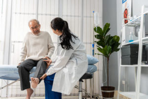 orthopedic doctor doing physical therapy procedure for elderly mature male