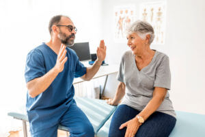 orthopedic surgeon talking to senior patient after orthopedic surgery