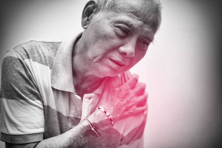 An elderly man placed his hand on his shoulder due to pain from a rotator cuff injury.