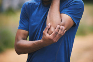 A man with pain in elbow after workout, possibly sign of tendinitis of the elbow.