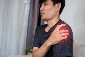 A Man Is Experiencing Shoulder Pain, Caused by Poor Posture, Muscle Strain.